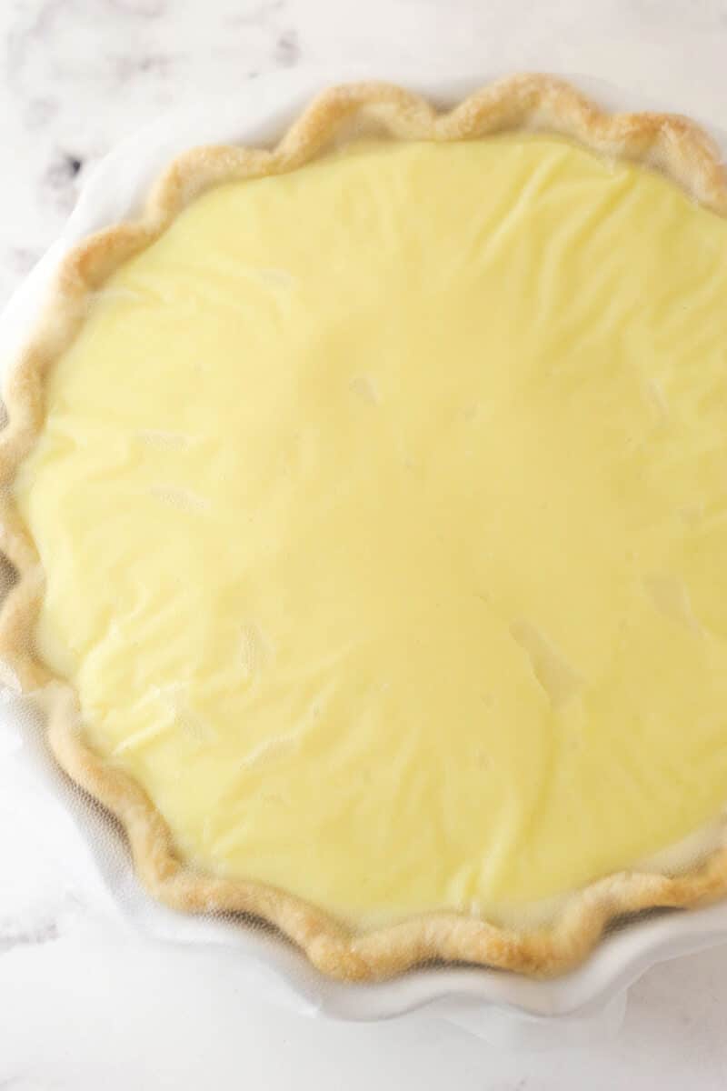 Plastic wrap pressed tightly on banana cream pie