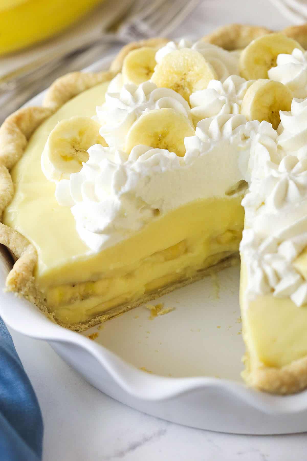 Banana cream pie with a slice removed to show the layers