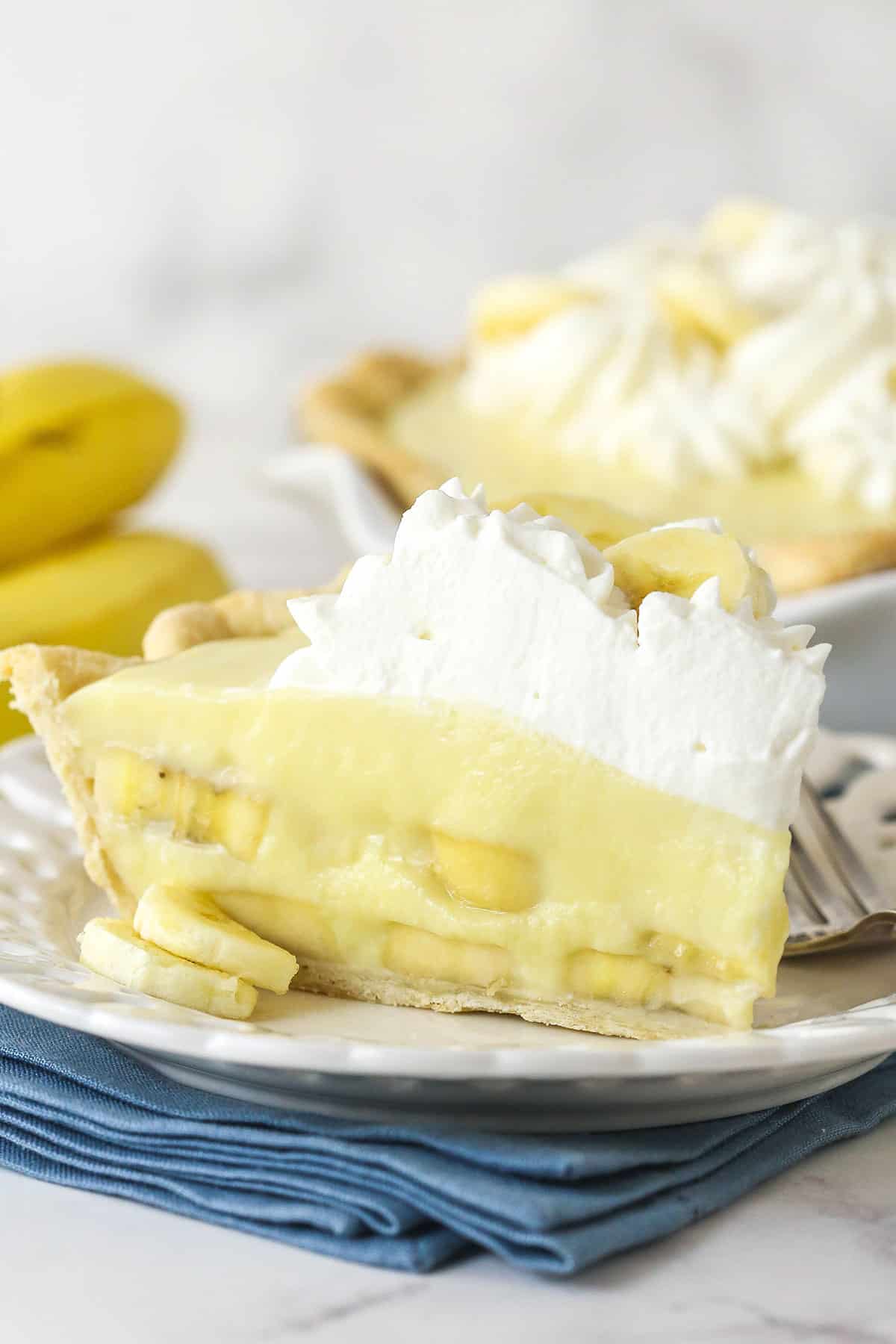 A slice of banana cream pie on a white plate