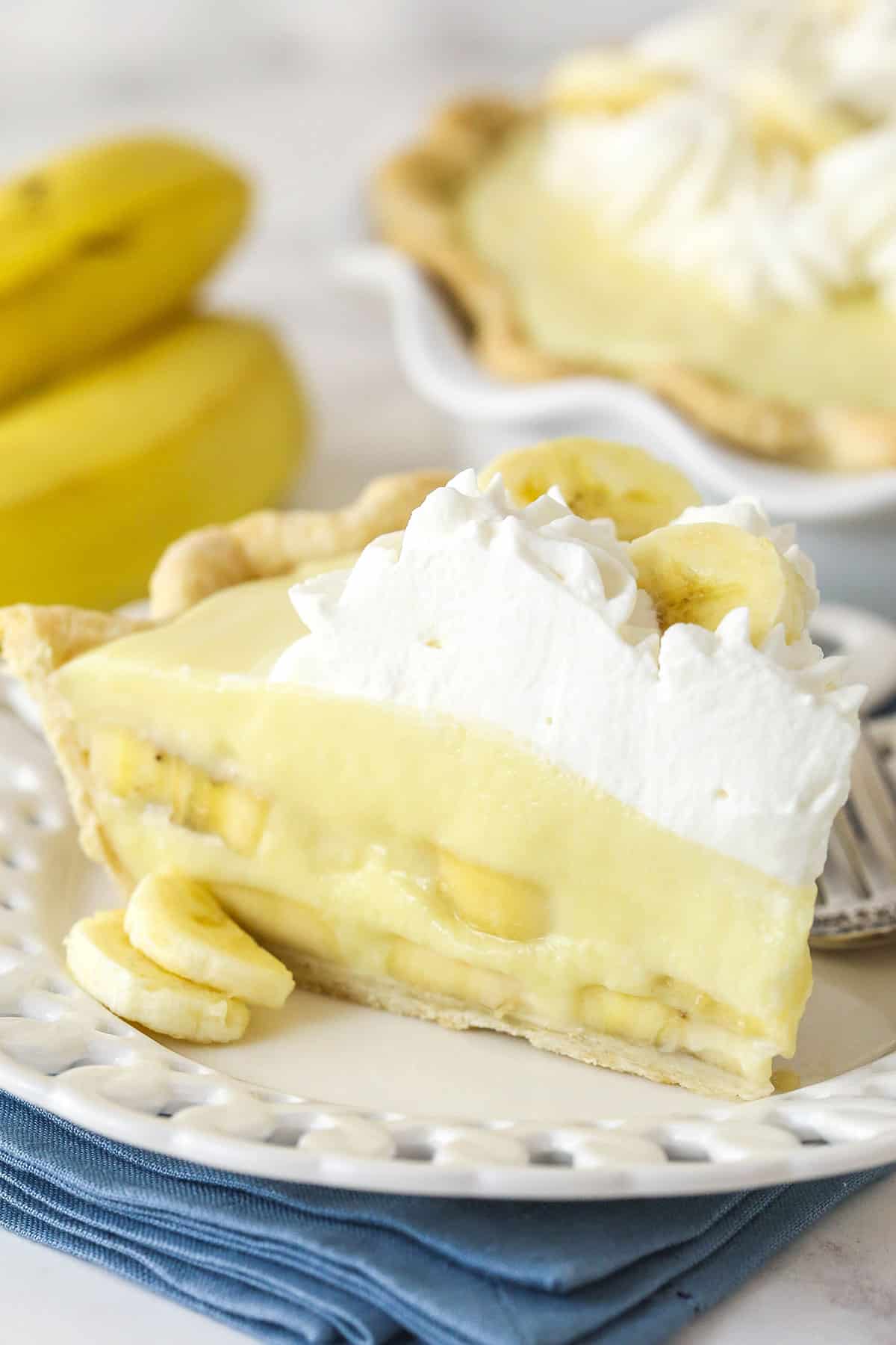 A slice of banana cream pie on a white plate