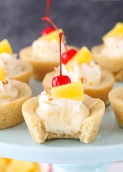 Pina Colada Cookie Cups on a cake stand with bite taken out of one