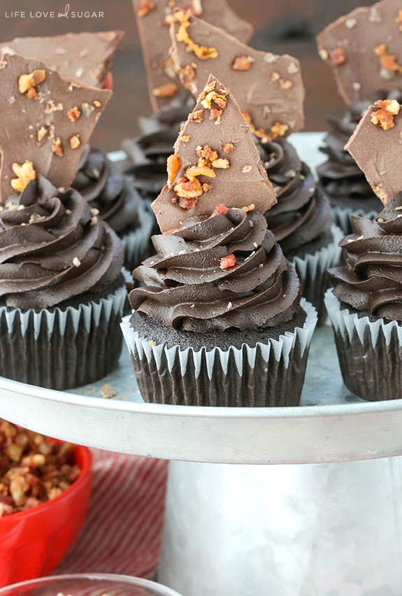 Close-up of Smokey Bourbon Chocolate Cupcakes with Bacon on a cake stand