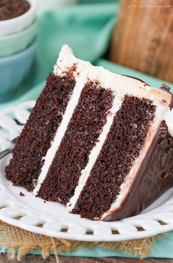 This Baileys chocolate cake combines two of my favorite things (Baileys and chocolate) in one amazing, moist chocolate layer cake recipe! Overhead image of a slice of baileys chocolate cake on a plate.