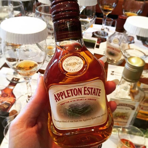 A Bottle of Appleton Estate Rum in Front of a Crowded Table