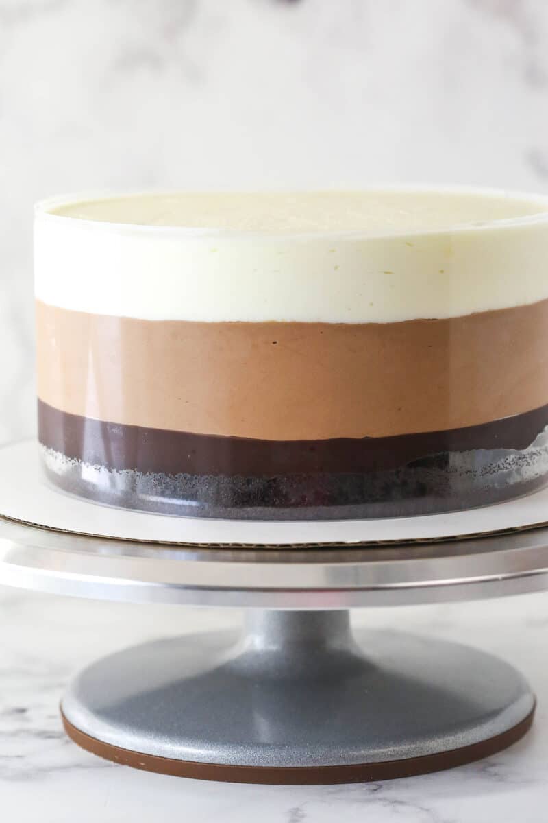 Triple chocolate mousse cake on a cake stand