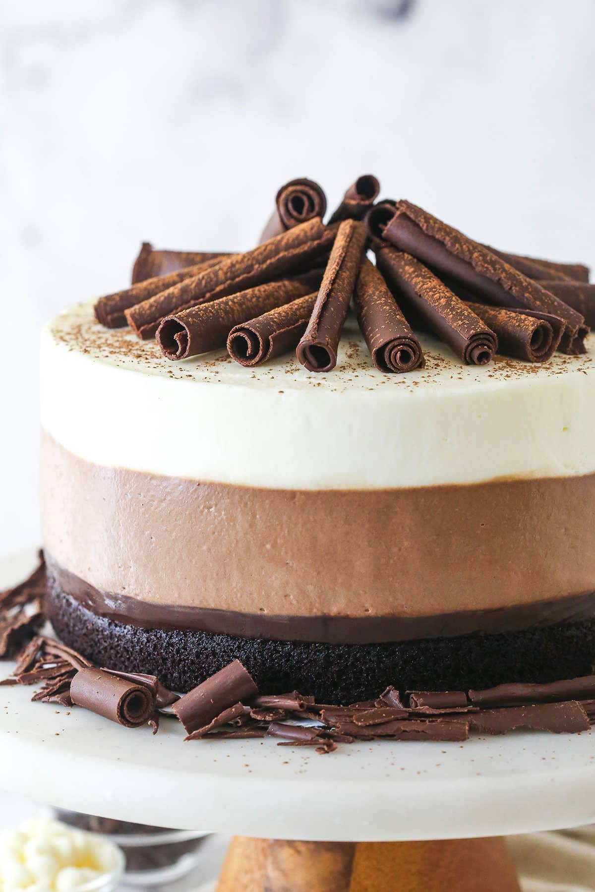 Triple chocolate mousse cake on a cake stand