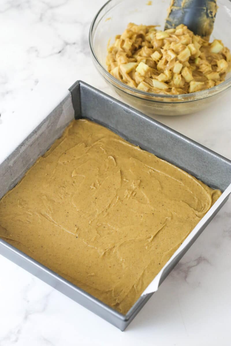 Every bite of these apple streusel bars is dotted with crunchy apples and warm fall flavors. Easy to make & perfect for breakfast or dessert! Batter spread in a square pan