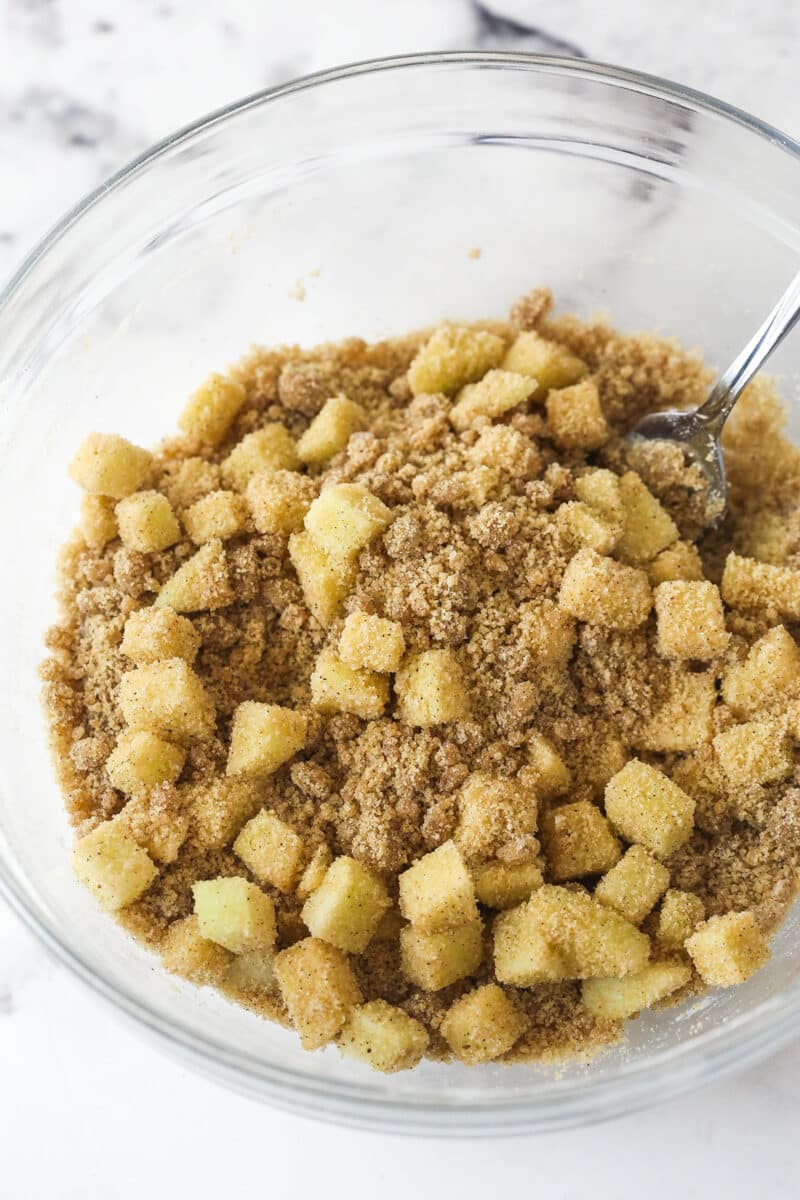 Every bite of these apple streusel bars is dotted with crunchy apples and warm fall flavors. Easy to make & perfect for breakfast or dessert! Diced apples in a bowl with streusel mixture
