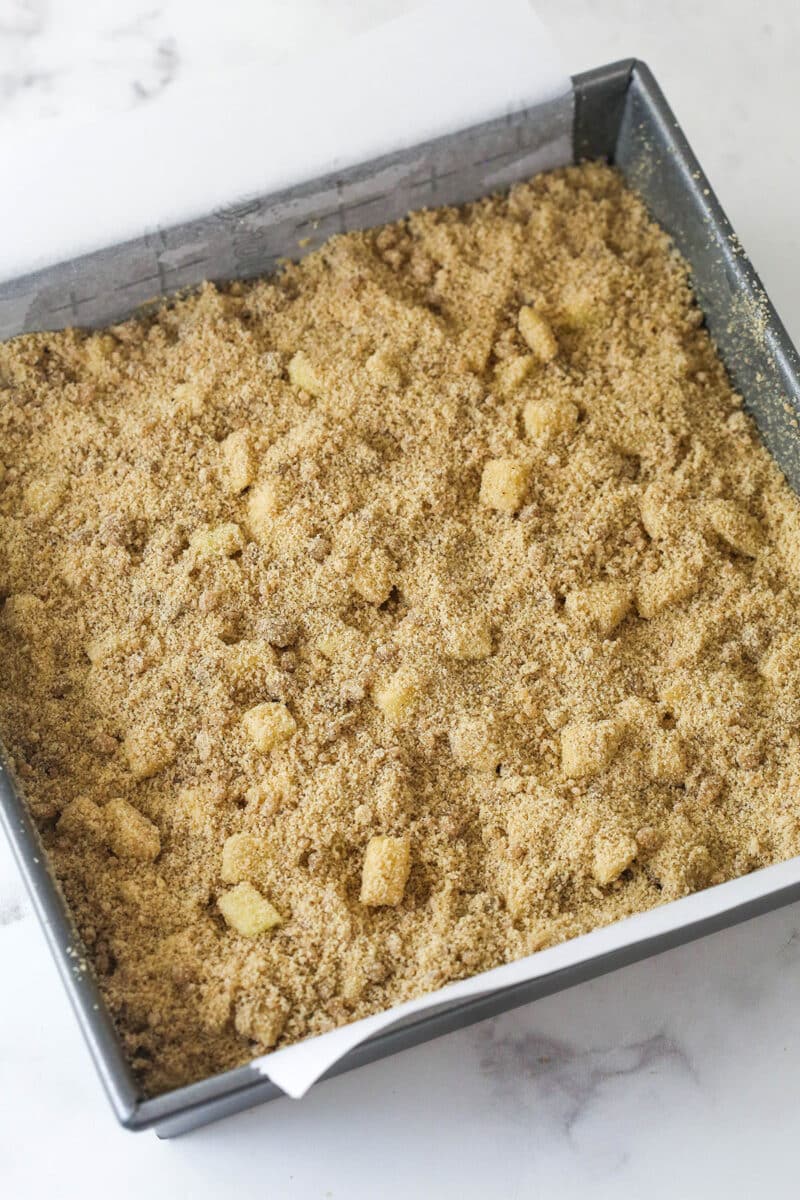 Every bite of these apple streusel bars is dotted with crunchy apples and warm fall flavors. Easy to make & perfect for breakfast or dessert! Apple streusel in a square pan