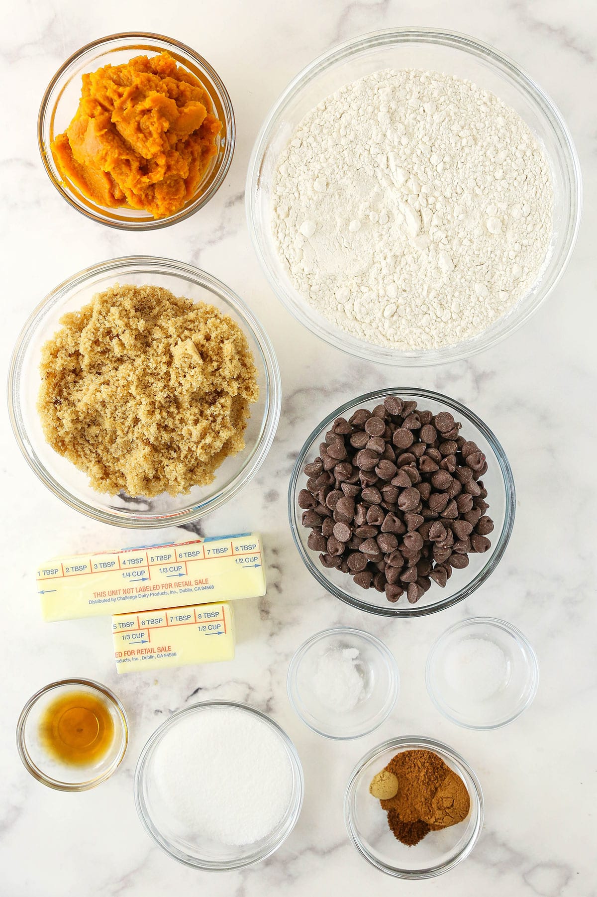 Pumpkin chocolate chip cookie ingredients on a marble countertop.