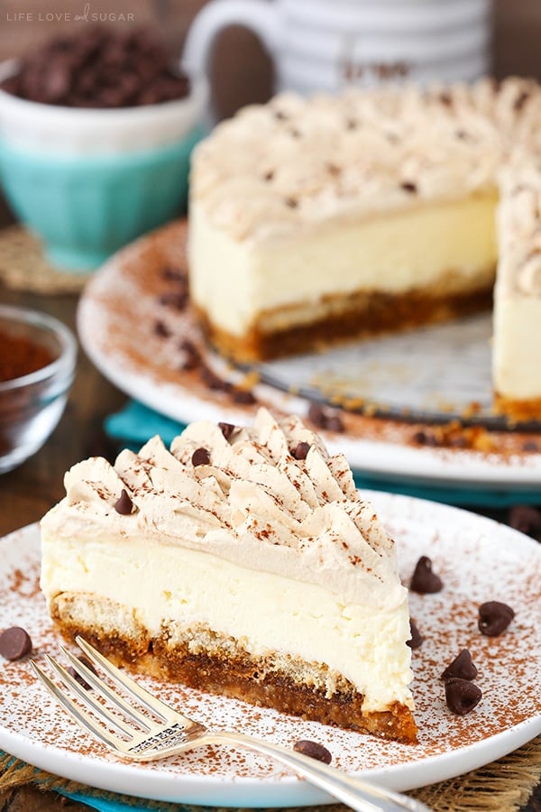 A slice of tiramisu cheesecake on a white plate with a fork