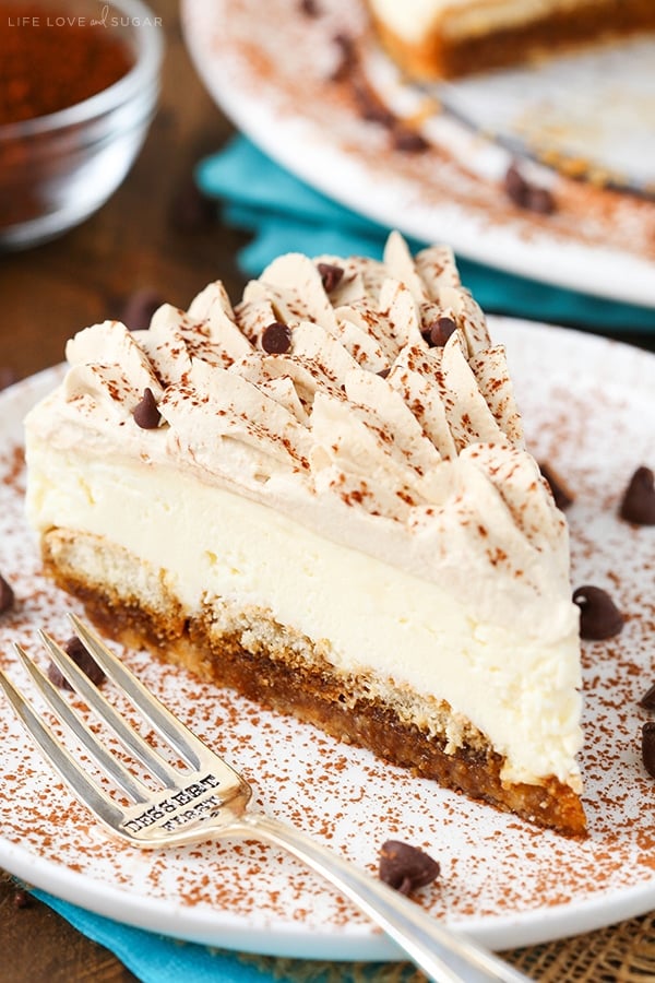 A slice of tiramisu cheesecake on a white plate with a fork