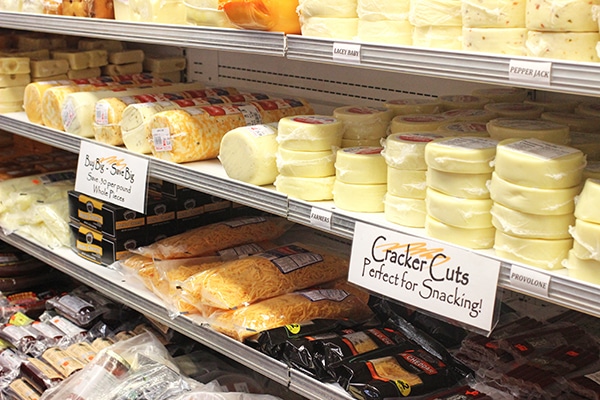 Shelves Filled with Different Kinds of Cheeses and their Labels