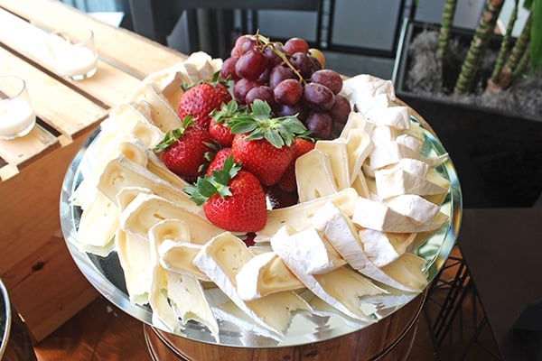 A Cheese Platter on a Silver Plate with Straberries and Grapes