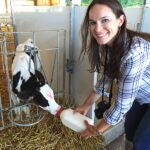 Lindsay Feeding a Calf and Smiling at the Camera