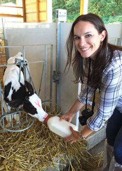 Lindsay Feeding a Calf and Smiling at the Camera