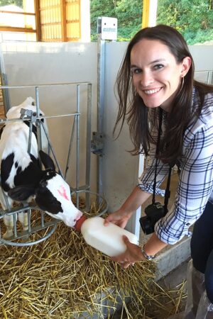 Lindsay Feeding a Calf and Smiling at the Camera