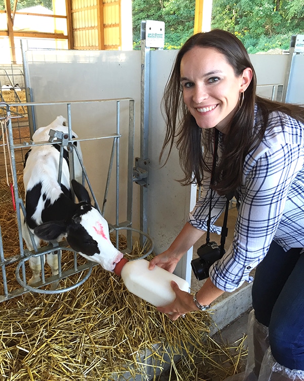 Lindsay Feeding a Calf and Smiling at the Camera