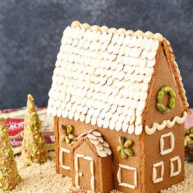 A homemade gingerbread house decorated with nuts.