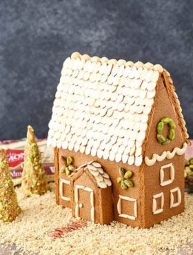 A homemade gingerbread house decorated with nuts