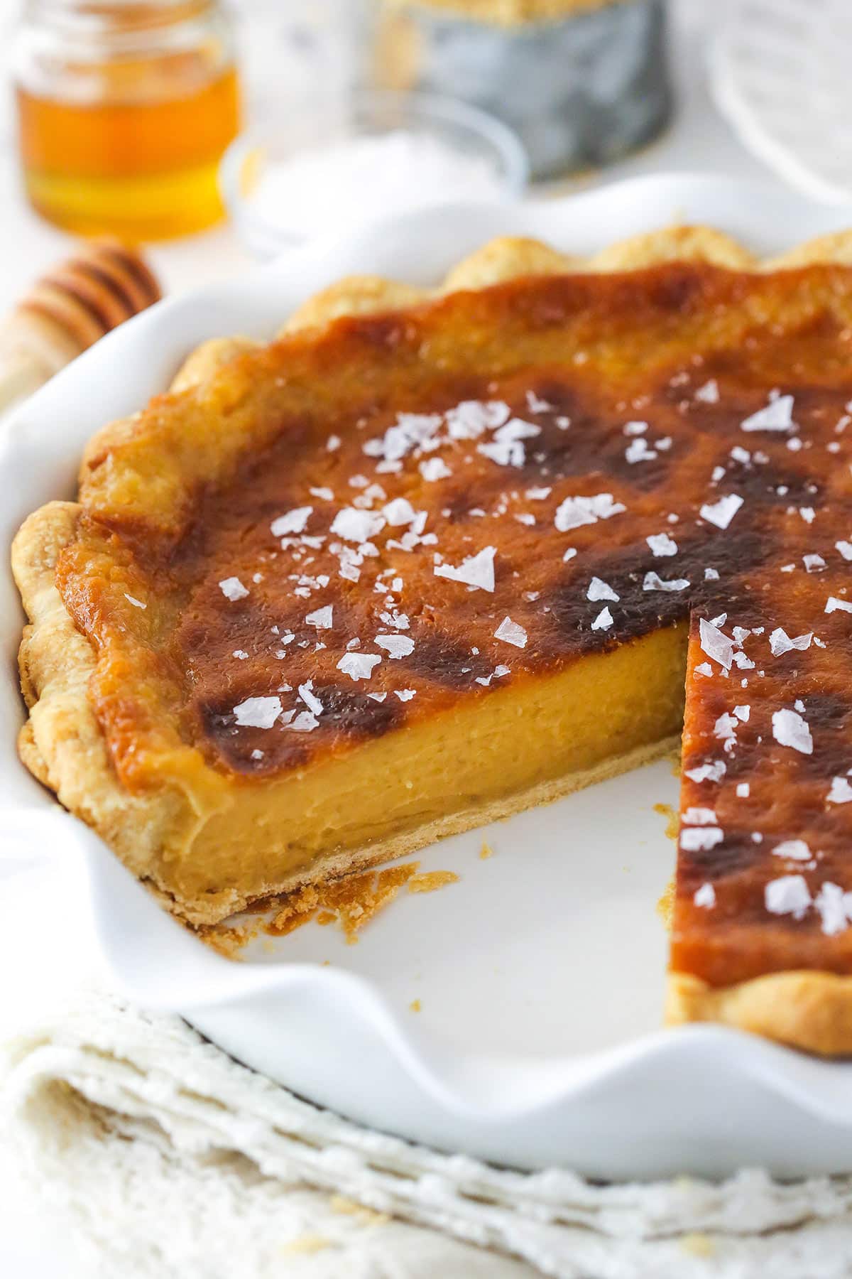Perfectly salty and sweet, this Salted Honey Pie features a creamy custard-based filling in a classic butter pie crust. Salted honey pie with a slice missing