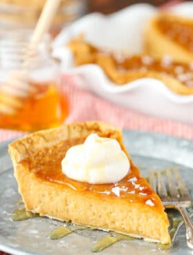 A slice of salted honey pie on a metal serving platter beside a large fork