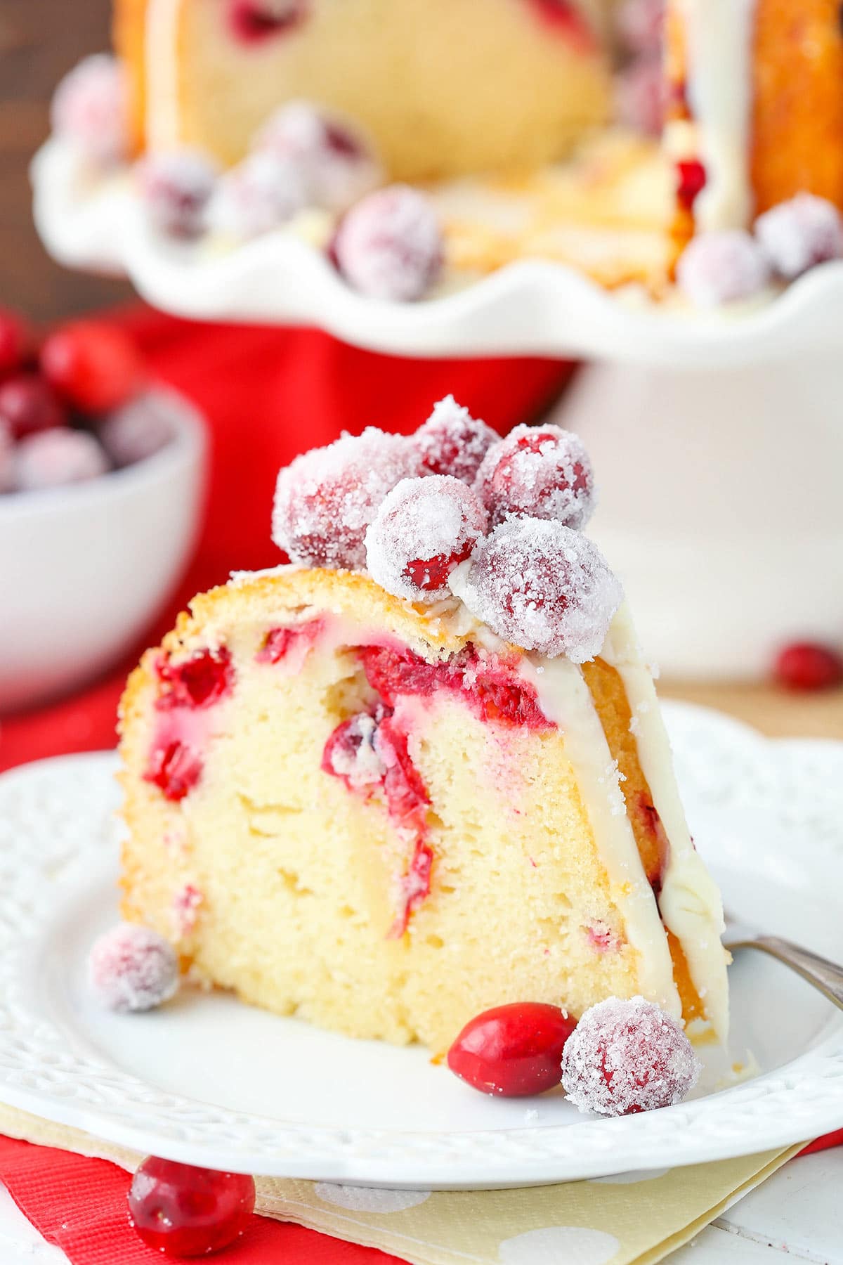 A close-up shot of a piece of white chocolate bundt cake on a plate with a fork