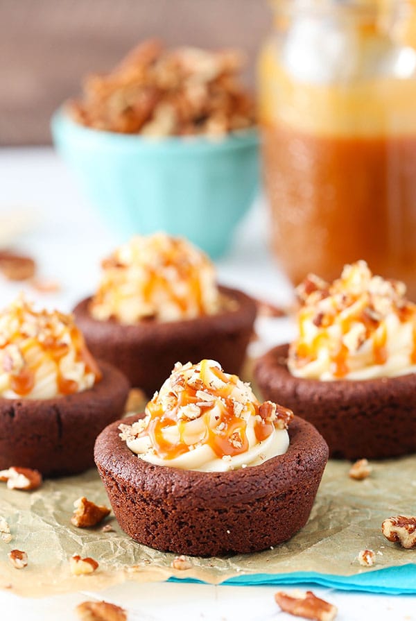 Turtle Chocolate Cookie Cups filled with caramel cheesecake and a sprinkle of pecans!