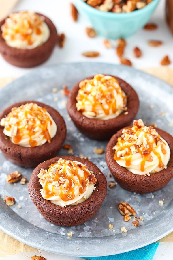 Turtle Chocolate Cookie Cups filled with caramel cheesecake and a sprinkle of pecans!