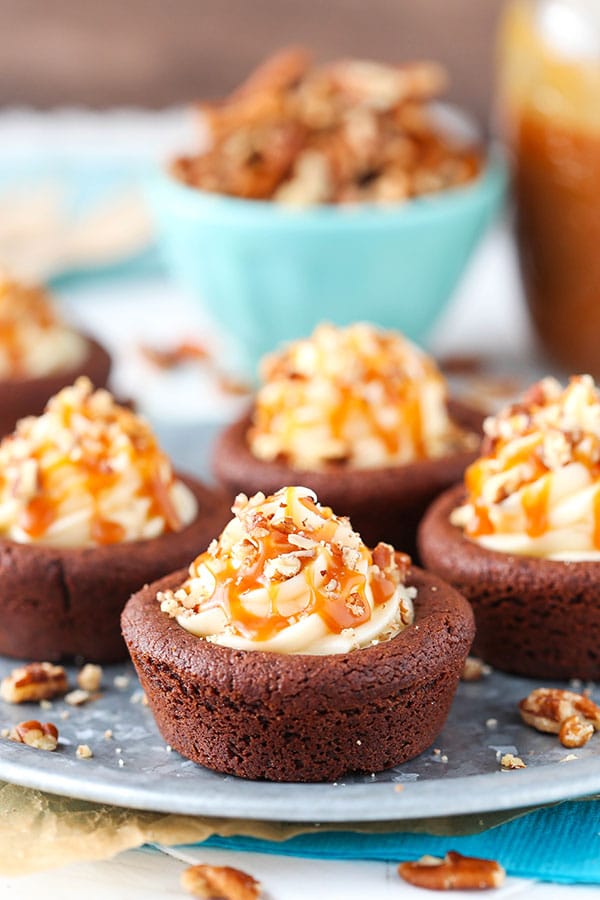 Turtle Chocolate Cookie Cups filled with caramel cheesecake and a sprinkle of pecans!