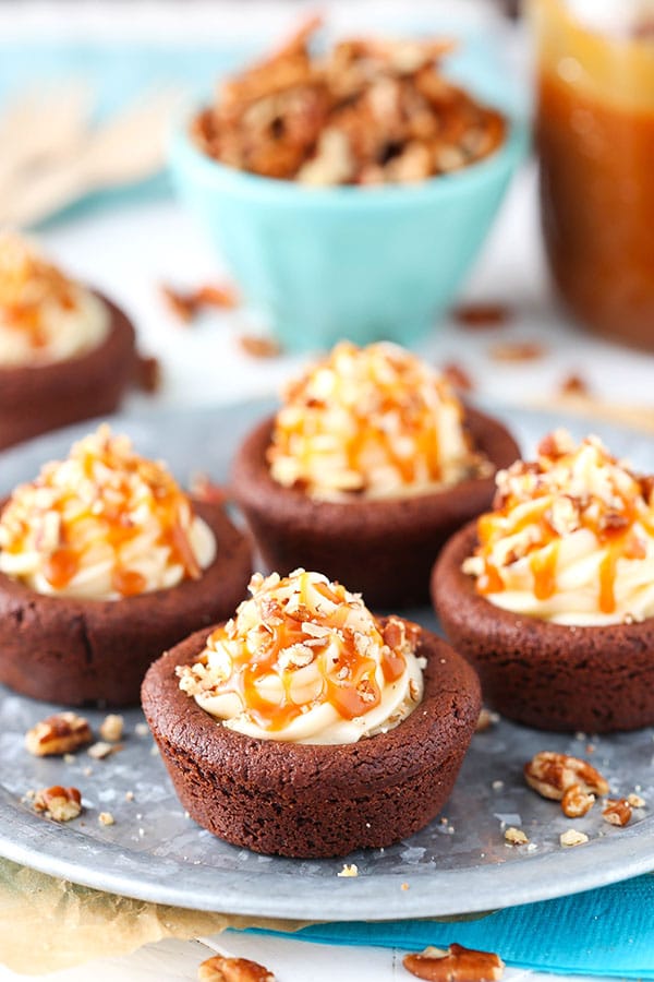 Turtle Chocolate Cookie Cups filled with caramel cheesecake and a sprinkle of pecans!