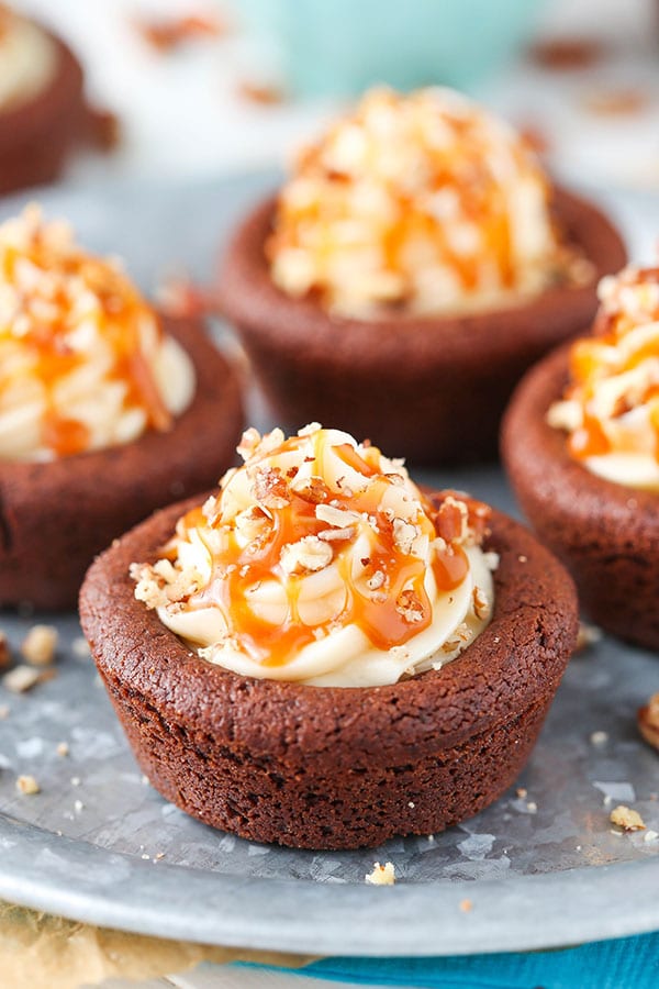 Turtle Chocolate Cookie Cups filled with caramel cheesecake and a sprinkle of pecans!