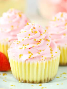 A close-up shot of a mini champagne cheesecake garnished with shiny gold star sprinkles