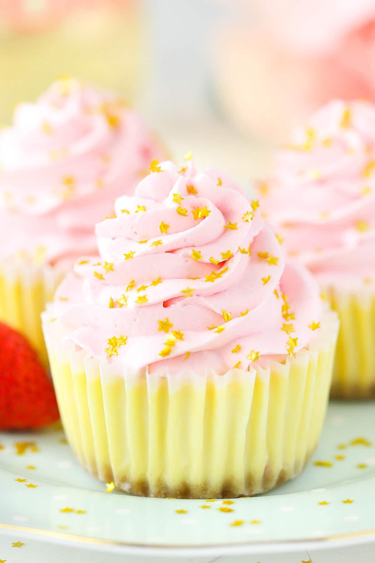 A close-up shot of a mini champagne cheesecake garnished with shiny gold star sprinkles