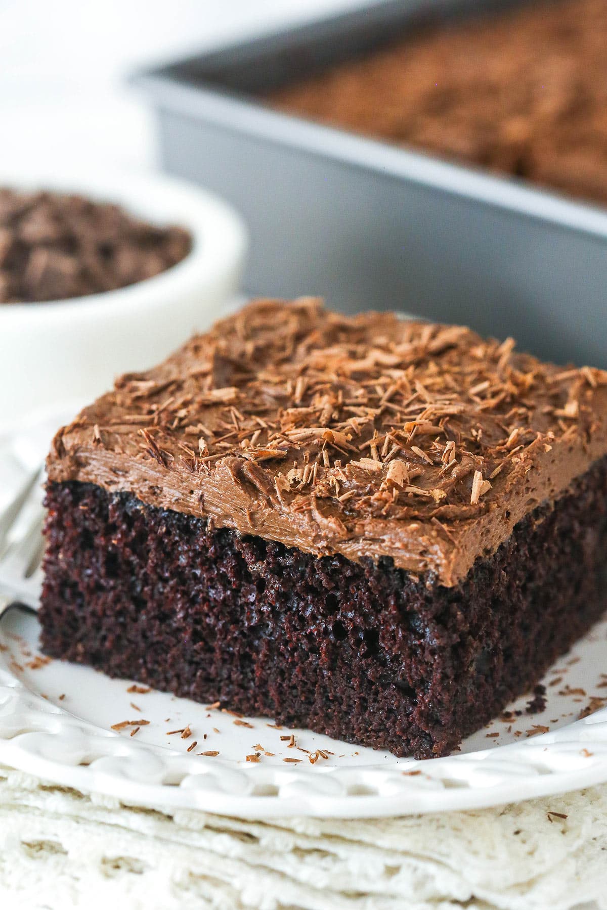 close up angled image of a slice of chocolate sheet cake on white plate