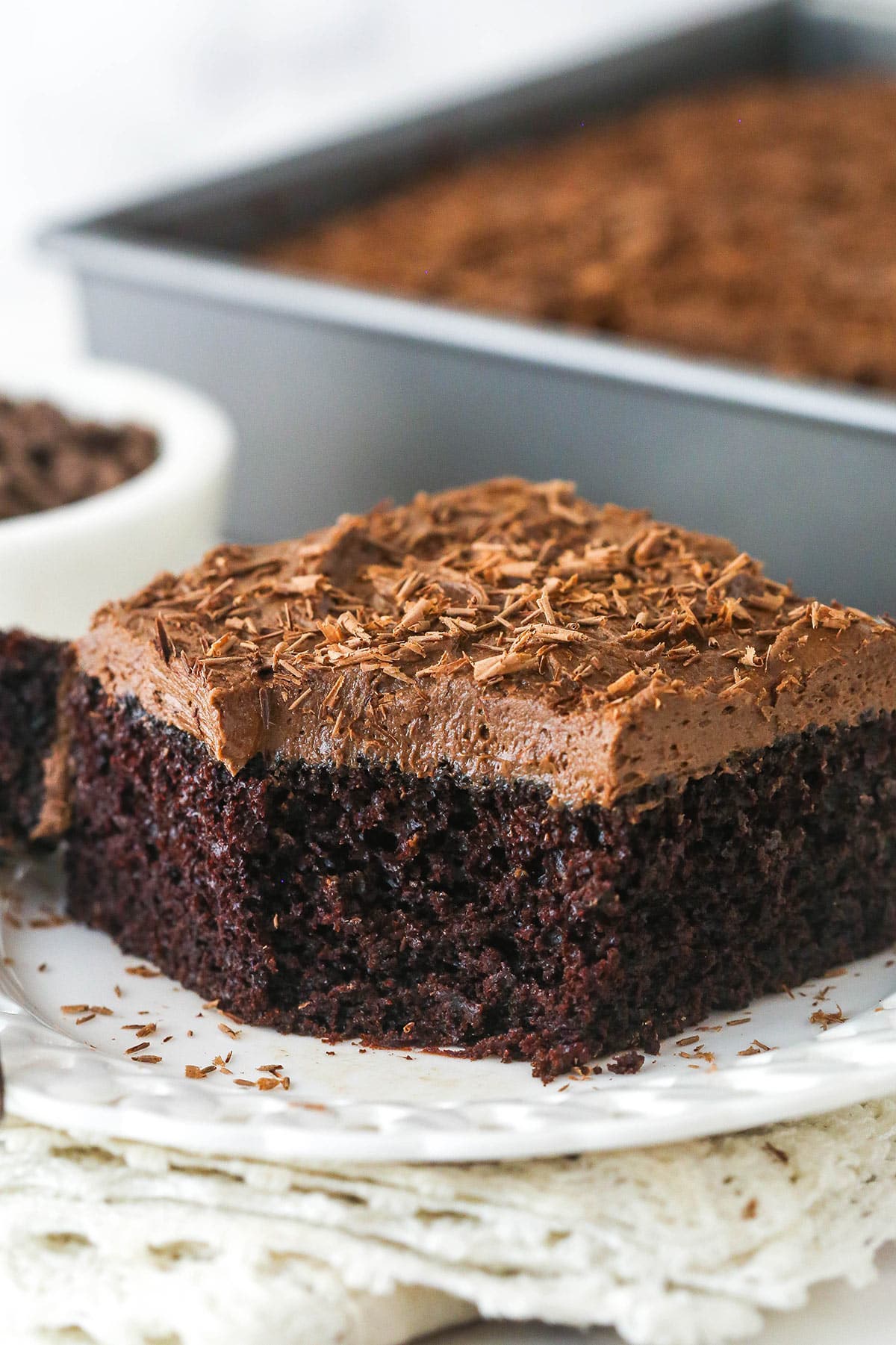slice of chocolate sheet cake on a plate with a bite taken out