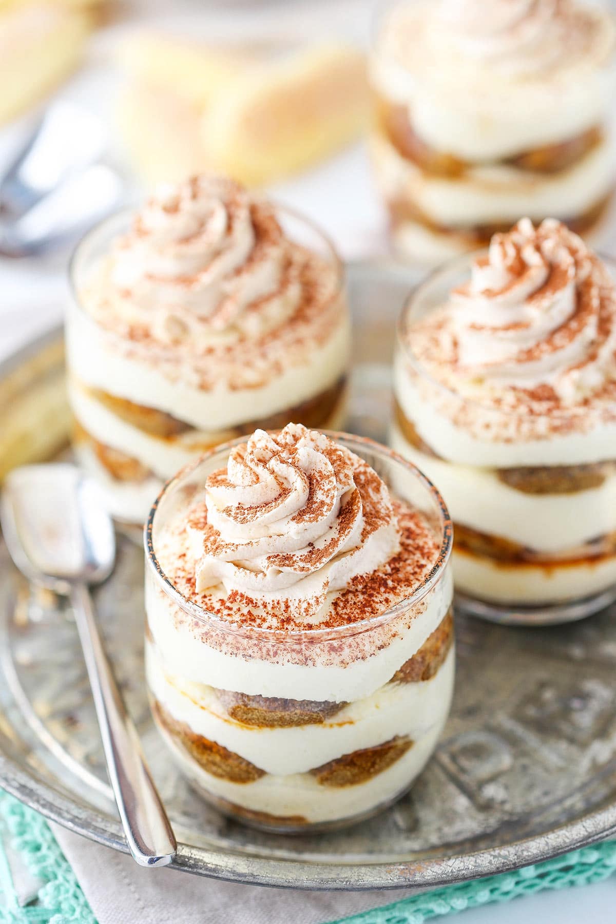 Three no-bake trifles with whipped cream and a dusting of cocoa powder on top of each one