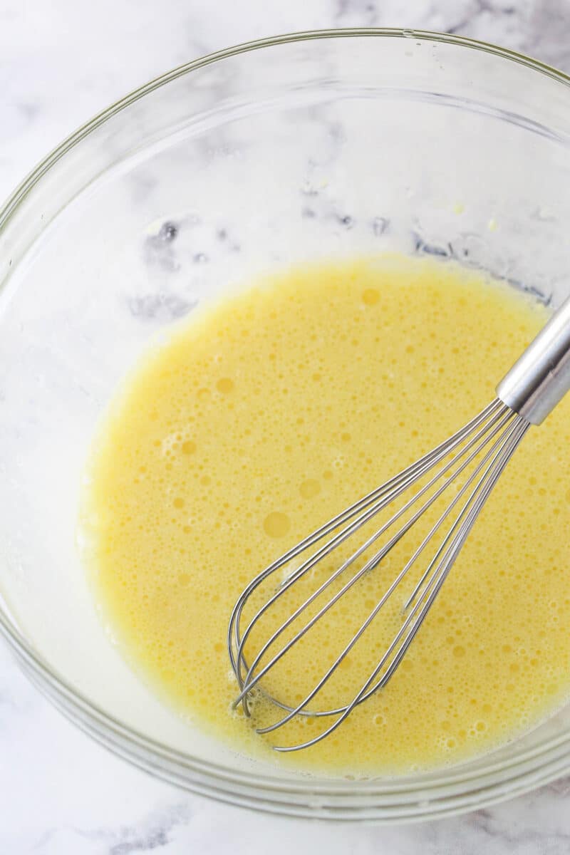 Whisking together oil, milk, eggs and vanilla.