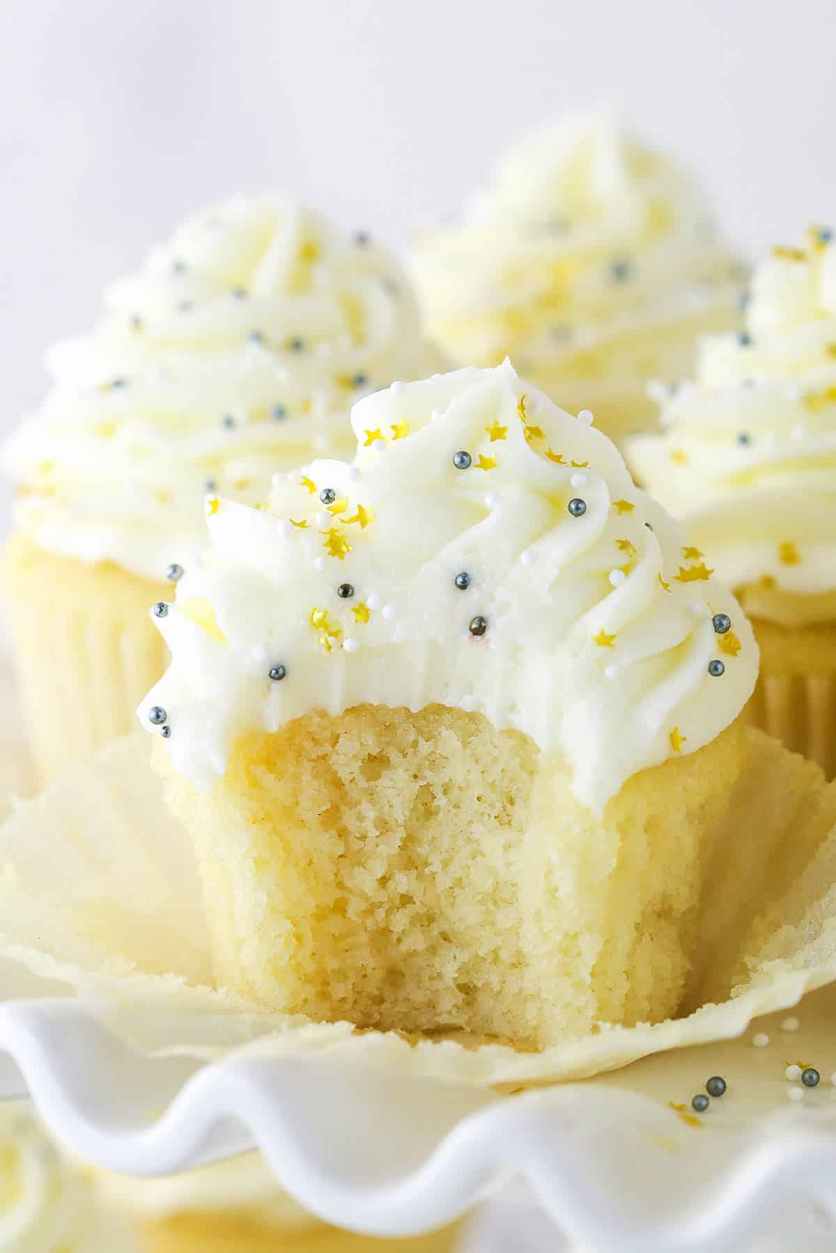 A moist vanilla cupcake with a bite missing