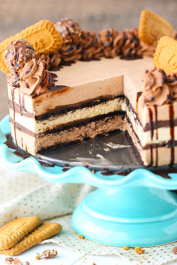 A Nutella Biscoff Icebox Cake with a slice missing exposing the layers of Nutella and Biscoff filling, and chocolate ganache