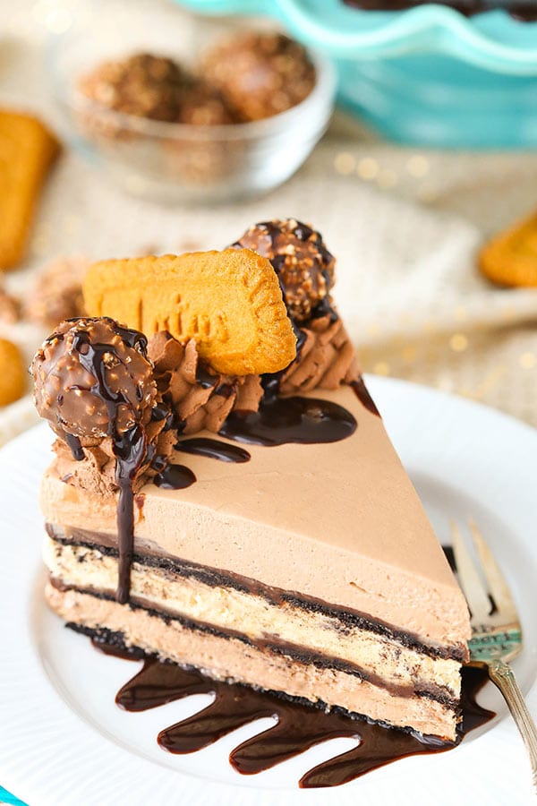 A slice of Icebox Cake with layers of Nutella and Biscoff filling, chocolate cookies and chocolate ganache on a white plate