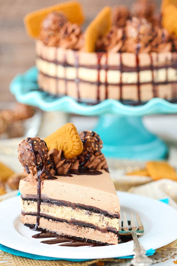 A white plate has a slice of Nutella Biscoff Icebox Cake and a fork on top