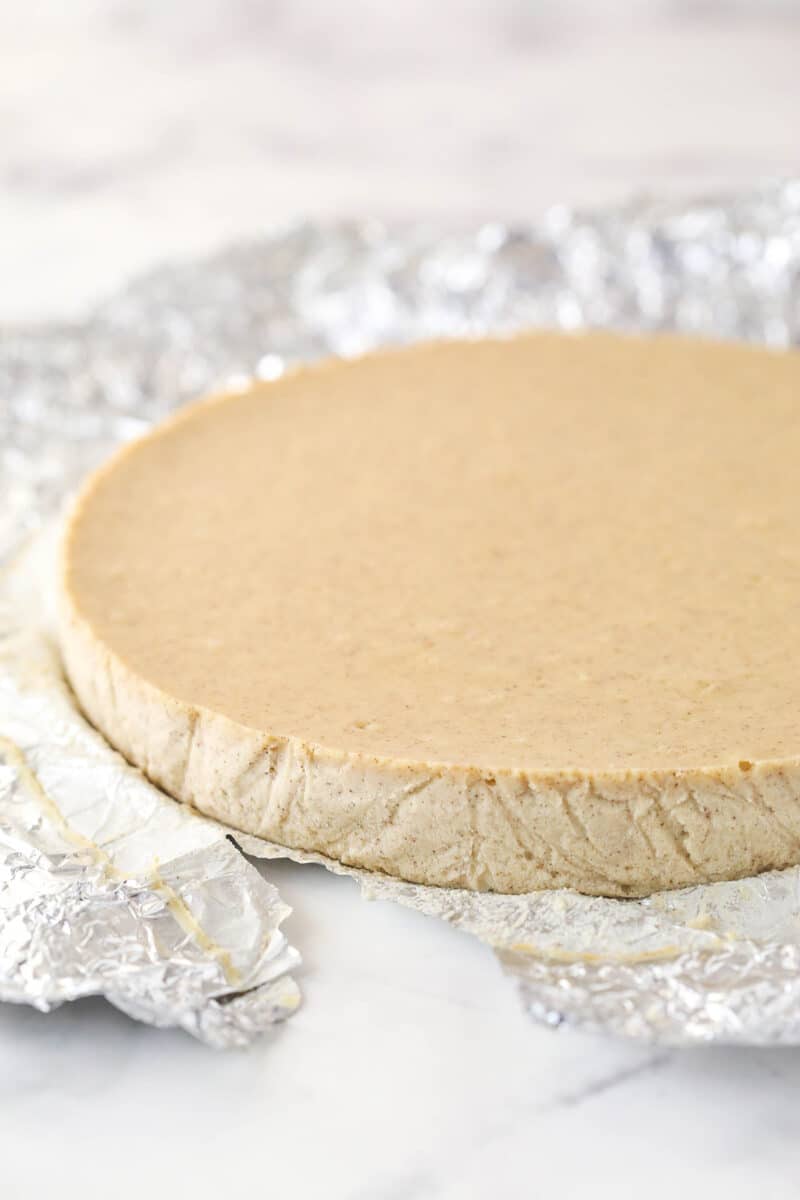baked and cooled cheesecake with foil being removed