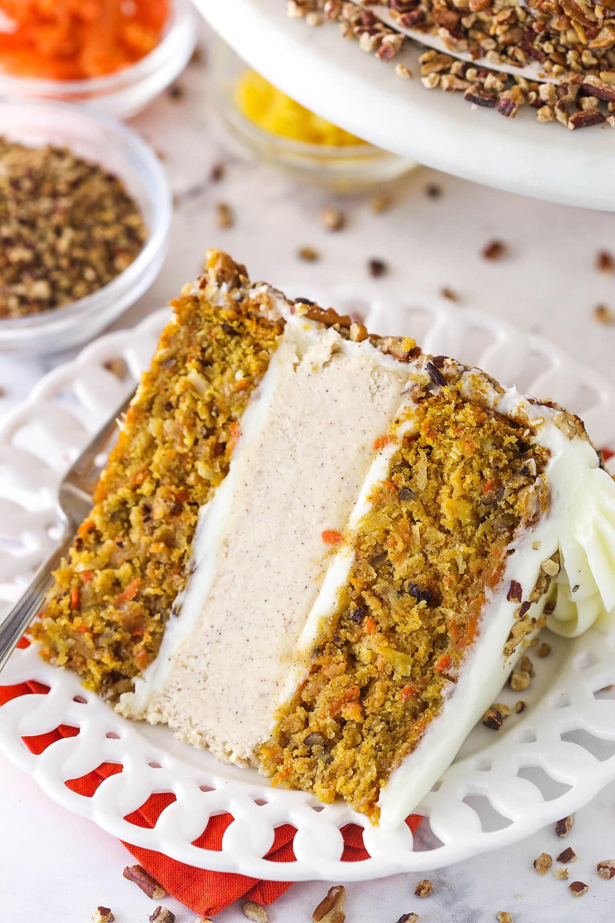 slice of carrot cake cheesecake cake on white plate