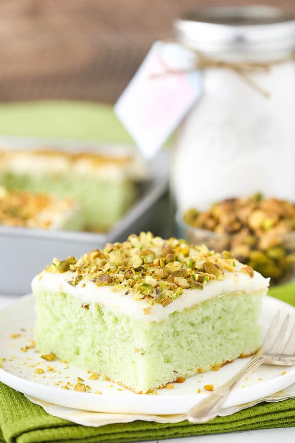 A Piece of Pistachio Cake Topped with Crushed Pistachios on a Plate
