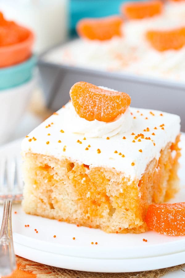 Image of a Slice of Orange Creamsicle Poke Cake on a Plate