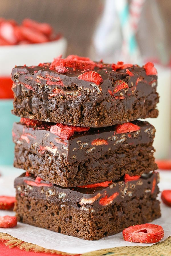 3 Fudgy Strawberry Chocolate Brownies stacked on parchment paper.