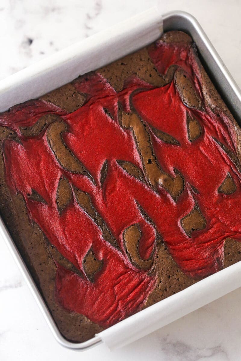 Strawberry sauce is swirled on top of moist, cakey brownies, adding a pop of color and fresh fruit flavor in these strawberry brownies. Strawberry brownies in a pan
