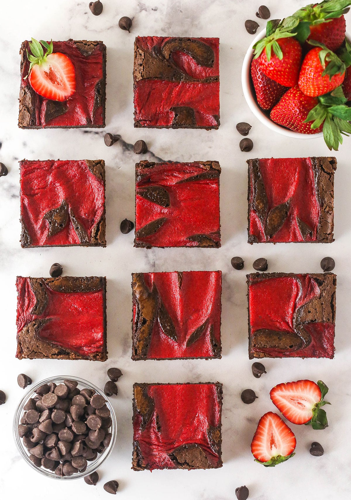 Strawberry sauce is swirled on top of moist, cakey brownies, adding a pop of color and fresh fruit flavor in these strawberry brownies. Overhead view of sliced strawberry brownies on the counter