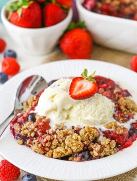 A scoop of triple berry crisp topped with vanilla ice cream.